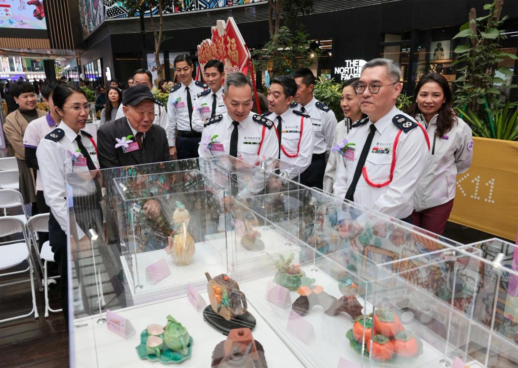 警務處處長周一鳴(中)與著名陶藝家何大鈞(左二)、香港警察工藝會主席徐湘兒(左一)及警務處副處長（國家安全）簡啟恩(右一)一同觀賞展品。