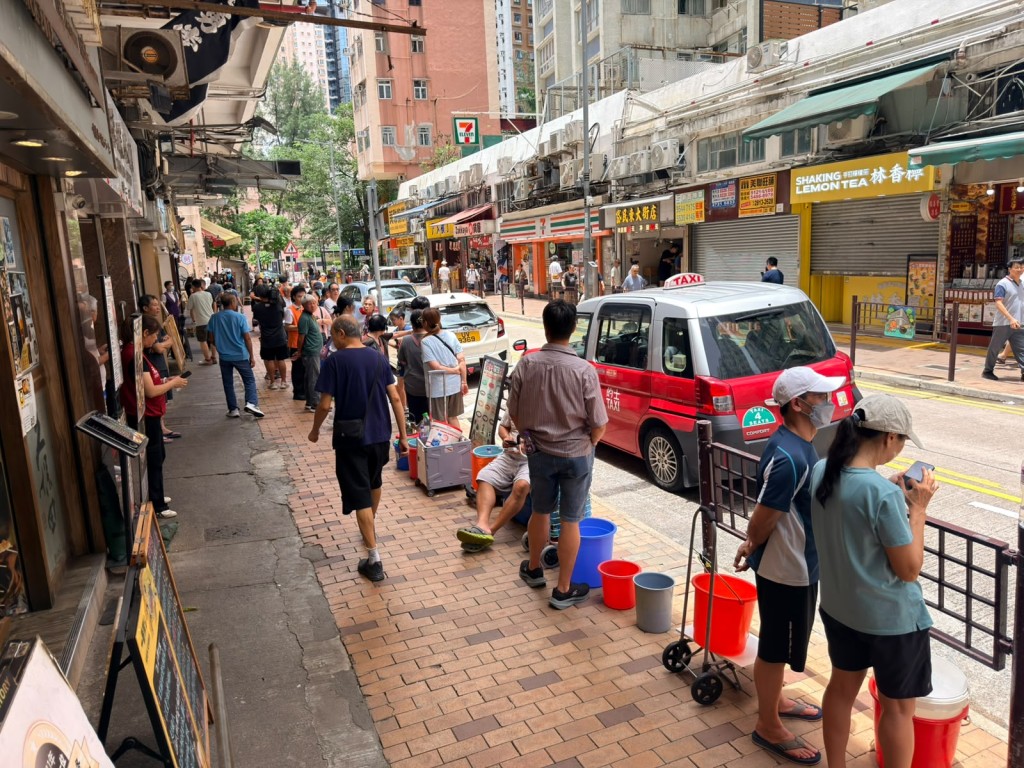 在東大街,約有30名市民在街頭等水車。 在東大街,約有30名市民在街頭等水車。