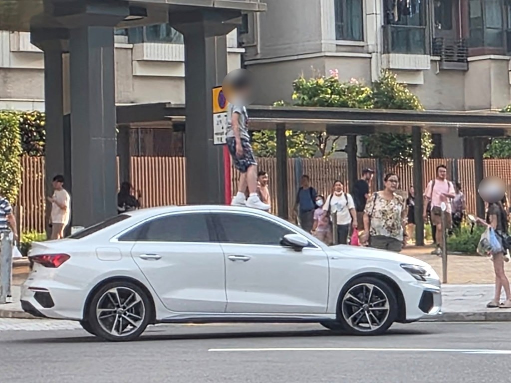 男童踩在車頂,女事主無奈旁觀。 男童踩在車頂,女事主無奈旁觀。