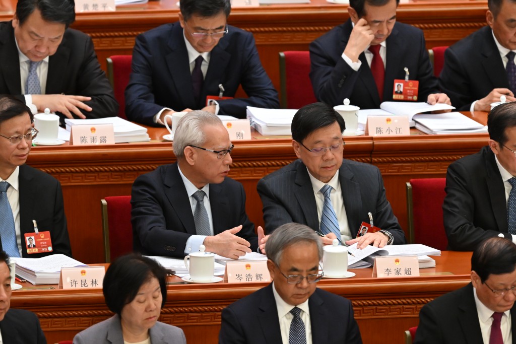 二人皆認真聆聽政府工作報告，期間岑浩輝一度「出手」指點。