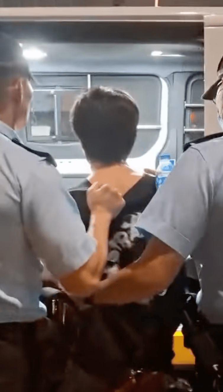 警员接报到场后，经初步调查将该名黑衫男子扣上手铐，由两名警员押上警车带回警署调查。网上影片截图