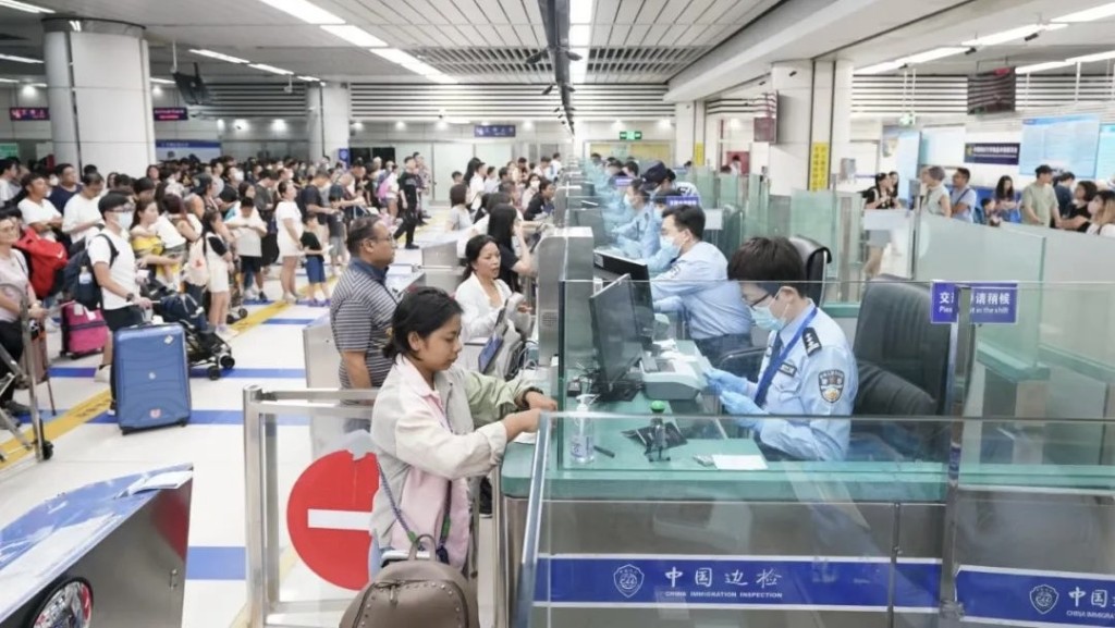 深圳湾边检站民警为旅客办理通关手续。