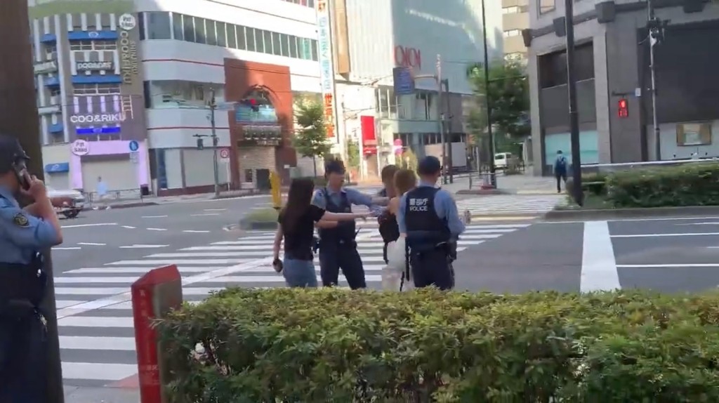 女子在馬路上與警員拉扯。