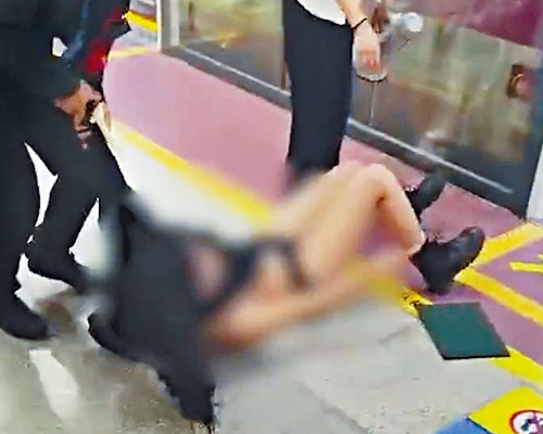 女乘客被保安人員拖出車廂甚狼狽。　