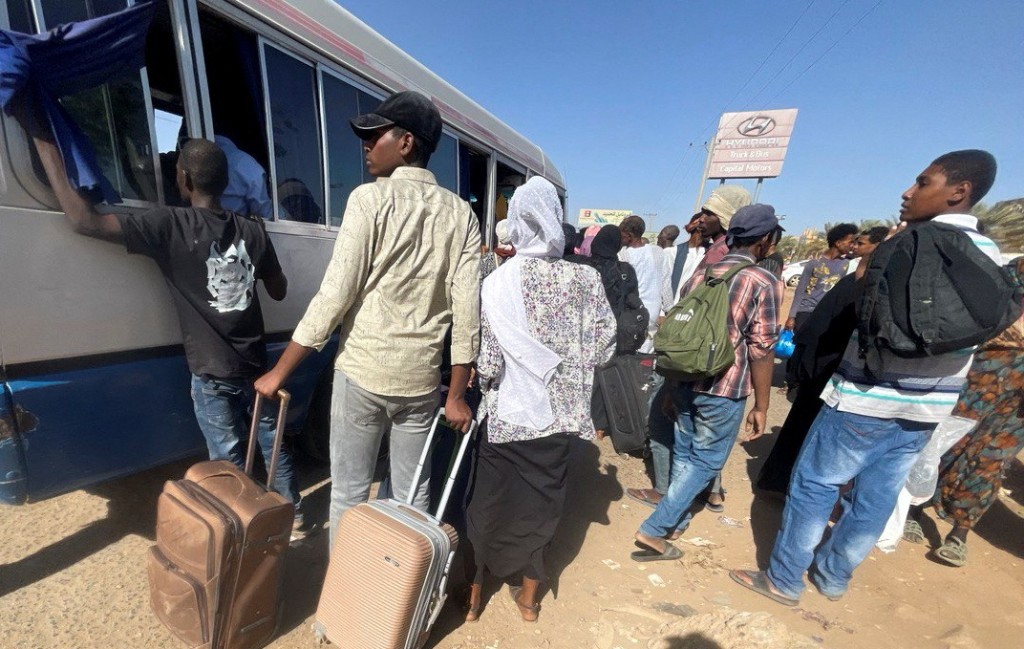 蘇丹民眾乘巴士離開逃避戰火。　路透社