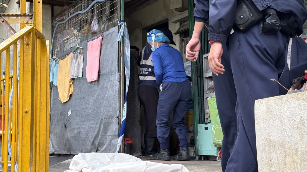 仵工在村屋移走死者的遺體。