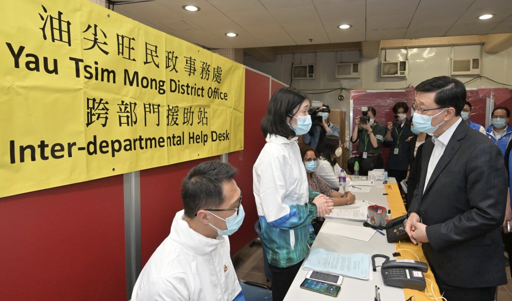 李家超（右一）视察医院内的跨部门援助站。政府新闻处
