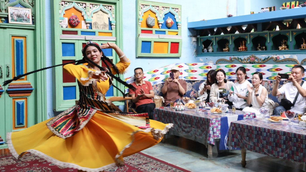 新疆喀什古城景區「古麗的家」旅遊家訪點，演員隨音樂起舞。  新華社