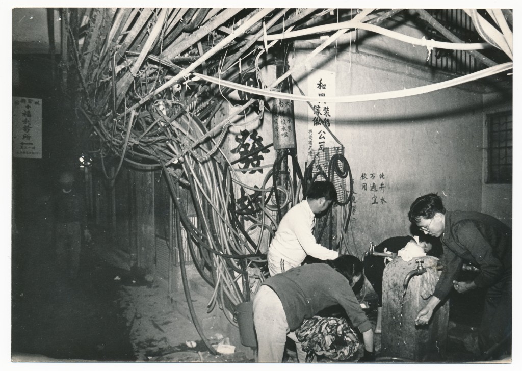 八十年代九龍城寨舊貌，電線胡亂鋪設，亦設有街喉供水。資料圖片