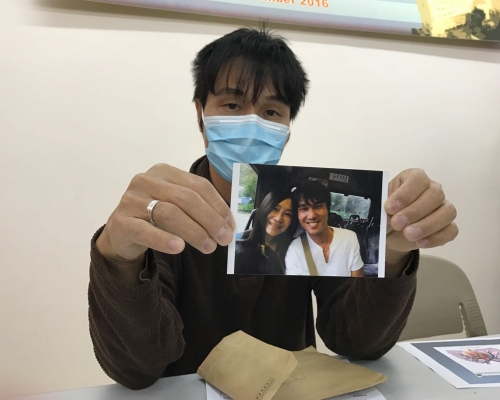 一臉愁容的羅生拿著7、8年前與愛妻的合照。