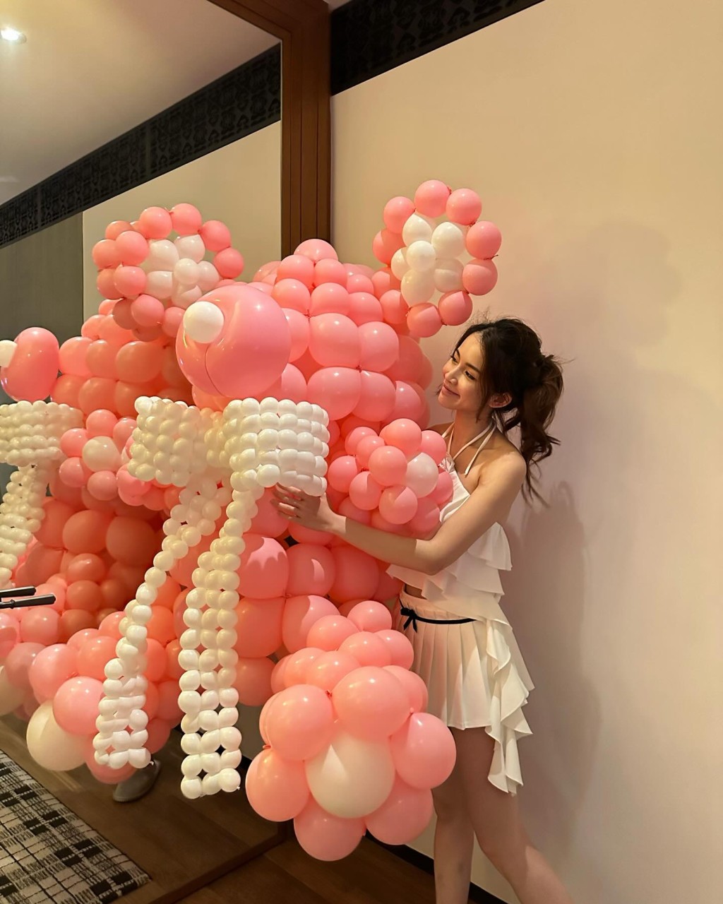 壽星女打扮性感，身穿吊帶露背top及短裙的她興奮地拿起約1米高的粉紅氣球熊仔。