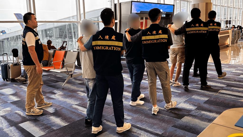 被遣返人士在入境處人員押送下離港。政府新聞處圖片
