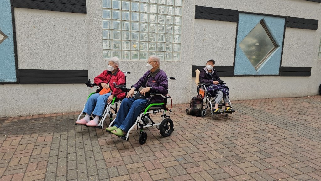 有长者乘坐轮椅在行人路上休息。(徐裕民摄)