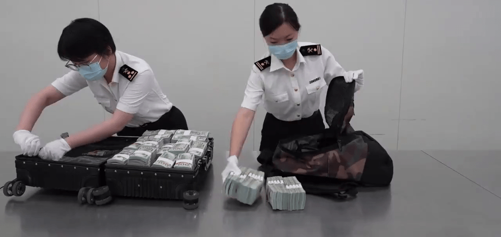 關員拿出一疊一疊的美金現鈔。 關員拿出一疊一疊的美金現鈔。