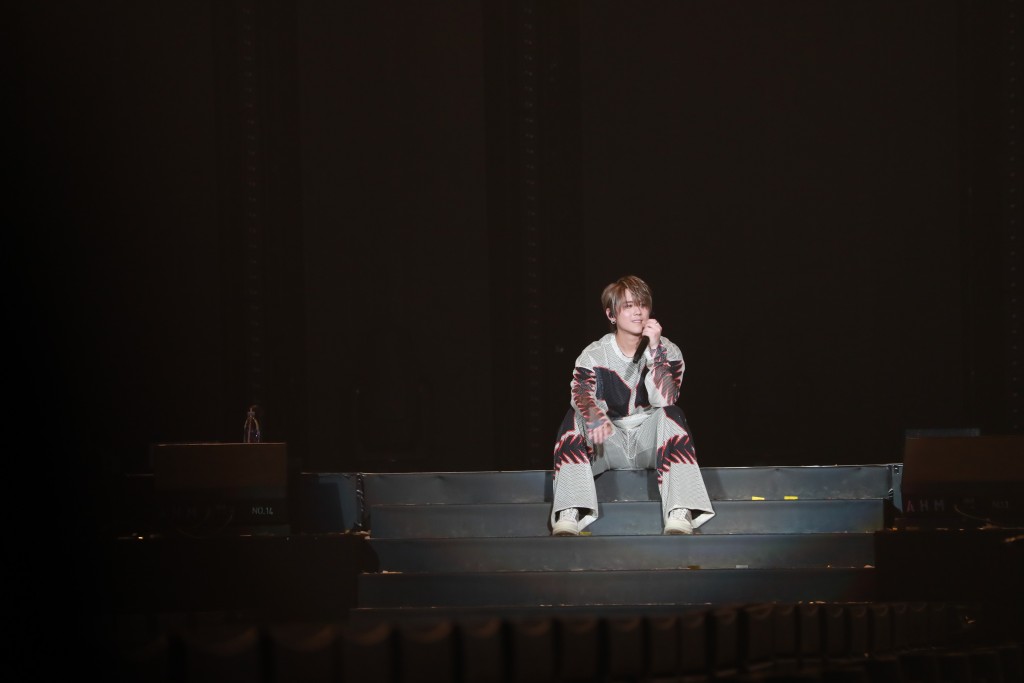 姜涛坐在台阶上与歌迷互动。