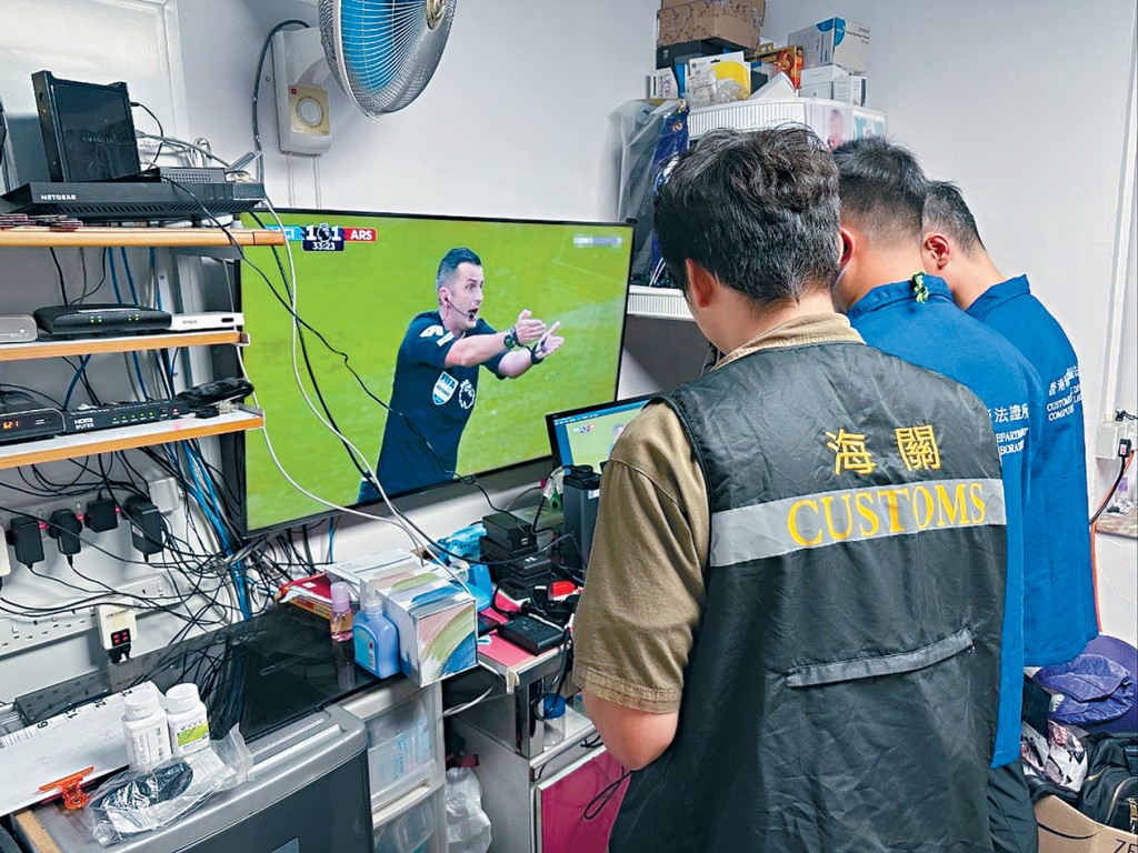 海关侦破以非法串流转播收费电视频道的足球赛事，拘捕一对父子。右图：被捕人遭海关人员带走调查。 