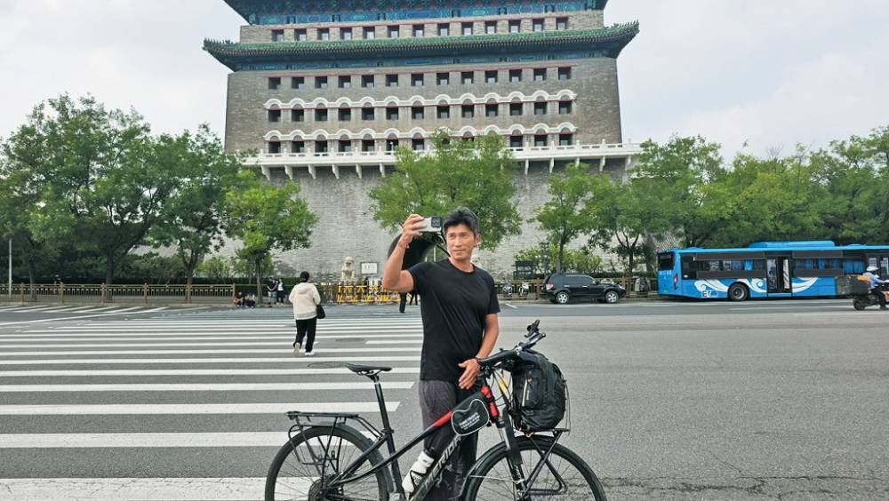 24日，台灣騎手陳峻永在北京正陽門前拍照。中新社