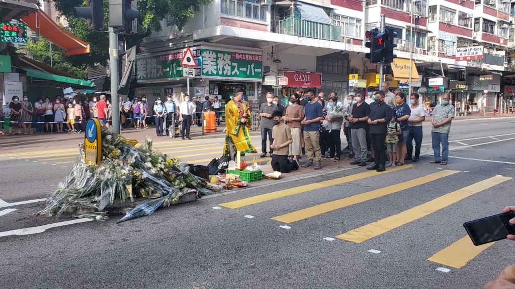 車禍死者的家人及親友在場拜祭，神情哀傷。