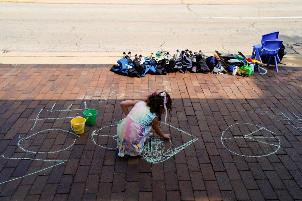  槍擊案現場仍散落著民眾物品，有小女孩在地面塗鴉。路透社圖片