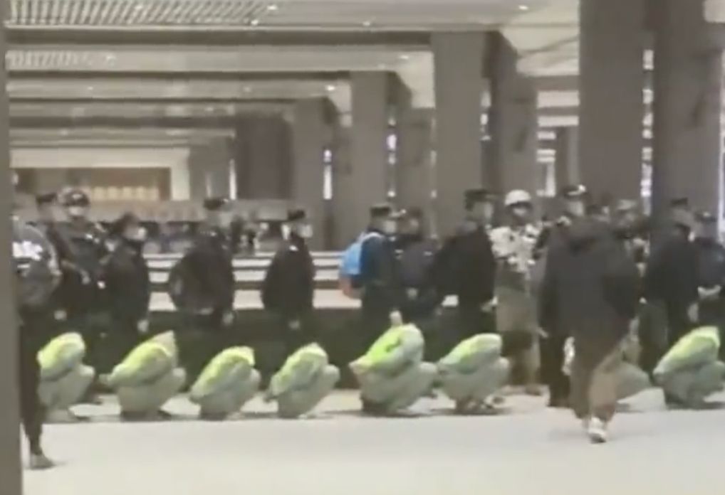 內地多地的火車站也出現戴黑頭套穿背心的押解回國受審的電騙疑犯。影片截圖