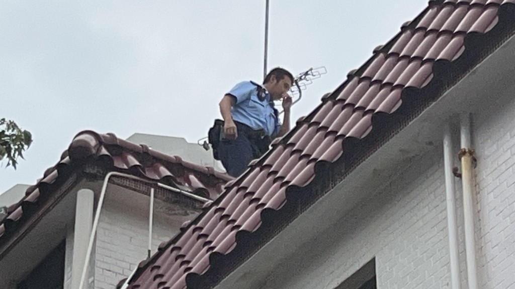 警員在村屋天台調查。 警員在村屋天台調查。