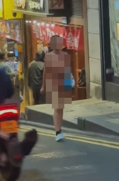 裸女沿蘭桂坊德己立街斜路行人路，走出馬路往上走。網上影片截圖