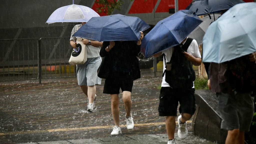 一眾打工仔又湧到天文台社交平台網頁再次狂轟天文台改發黑雨信號的時間。盧江球攝