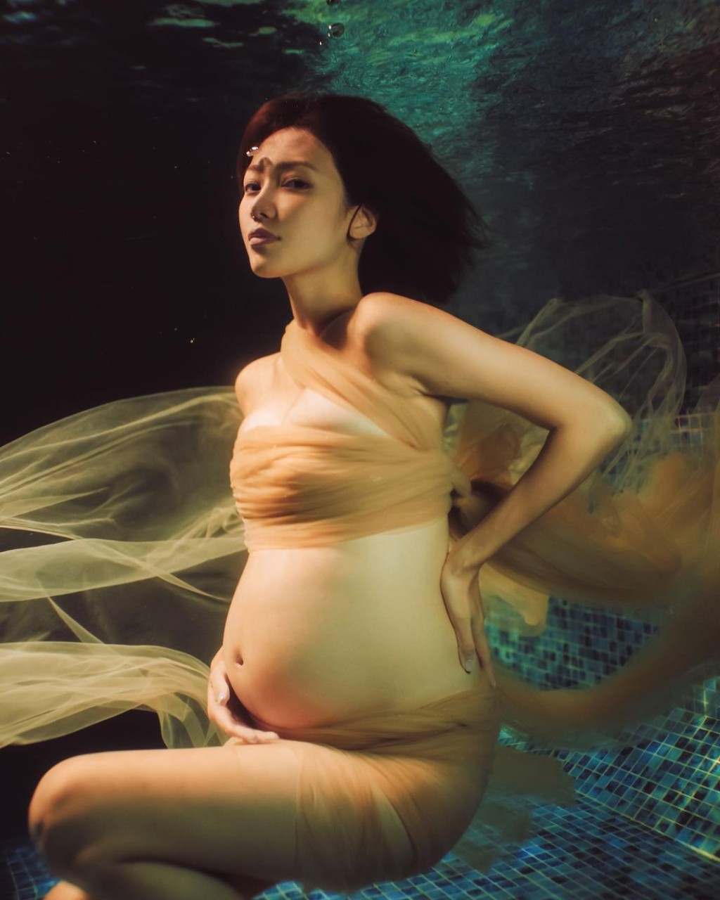 即使在水底拍照,倪晨曦(Elva)依然可張開眼,露出幸福及充滿母愛的眼神和笑容。(圖片來源:「misselvani」Instagram)