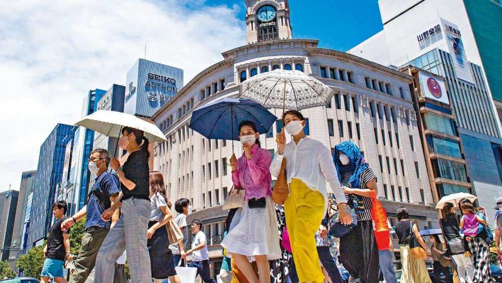 東京天氣炎熱，途經銀座區的民眾紛紛撐傘遮太陽。