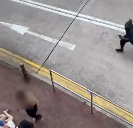 外傭跑過馬路後，不慎跌倒地上。疑兇近在咫尺。網片截圖