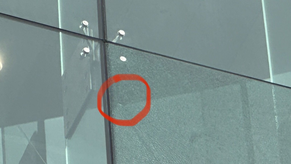 玻璃外墙出现怀疑弹孔（红圈示）。刘汉权摄