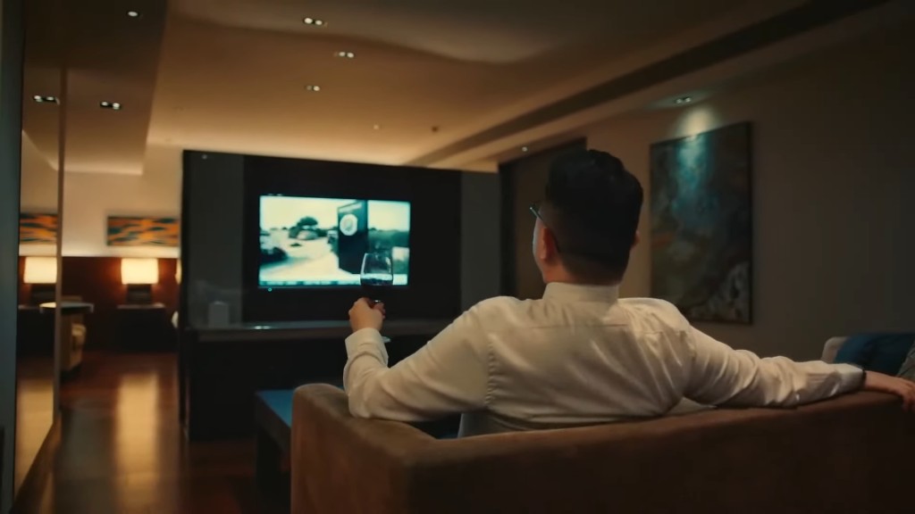 镜头一转见到蔡康年坐在酒店房内。