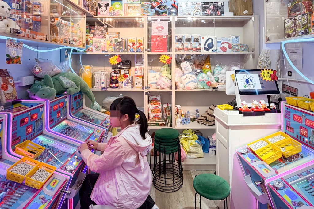 屯門一街市有彈珠機店入駐，有小學生經過時被彈珠機吸引，駐足在機前不願走。