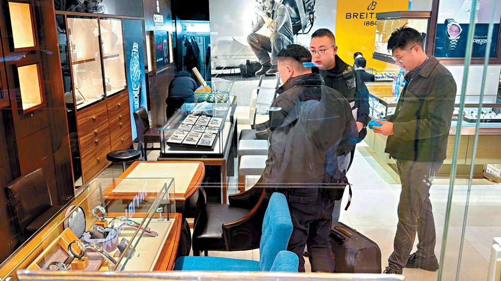 警員在被搶劫名錶的珠寶鐘錶店調查。 