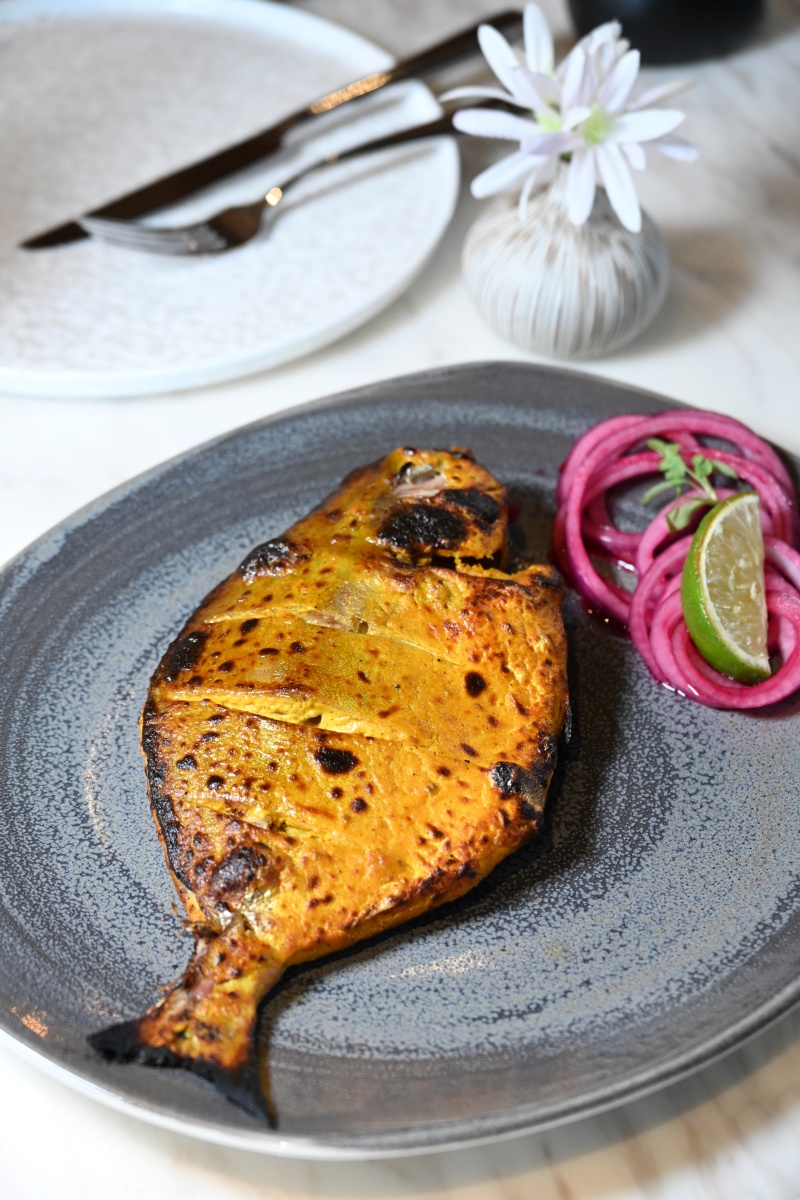 Tandoori Pomfret 原條鯧魚高溫烤熟保留肉汁，再淋上少許新鮮檸檬汁，令魚肉吃起來更清甜。