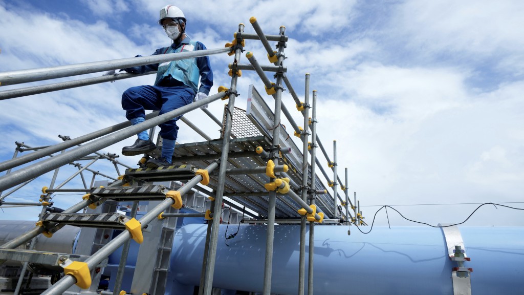 福島第一核電站職員走過排放核污水用的海水輸送管道。 路透社