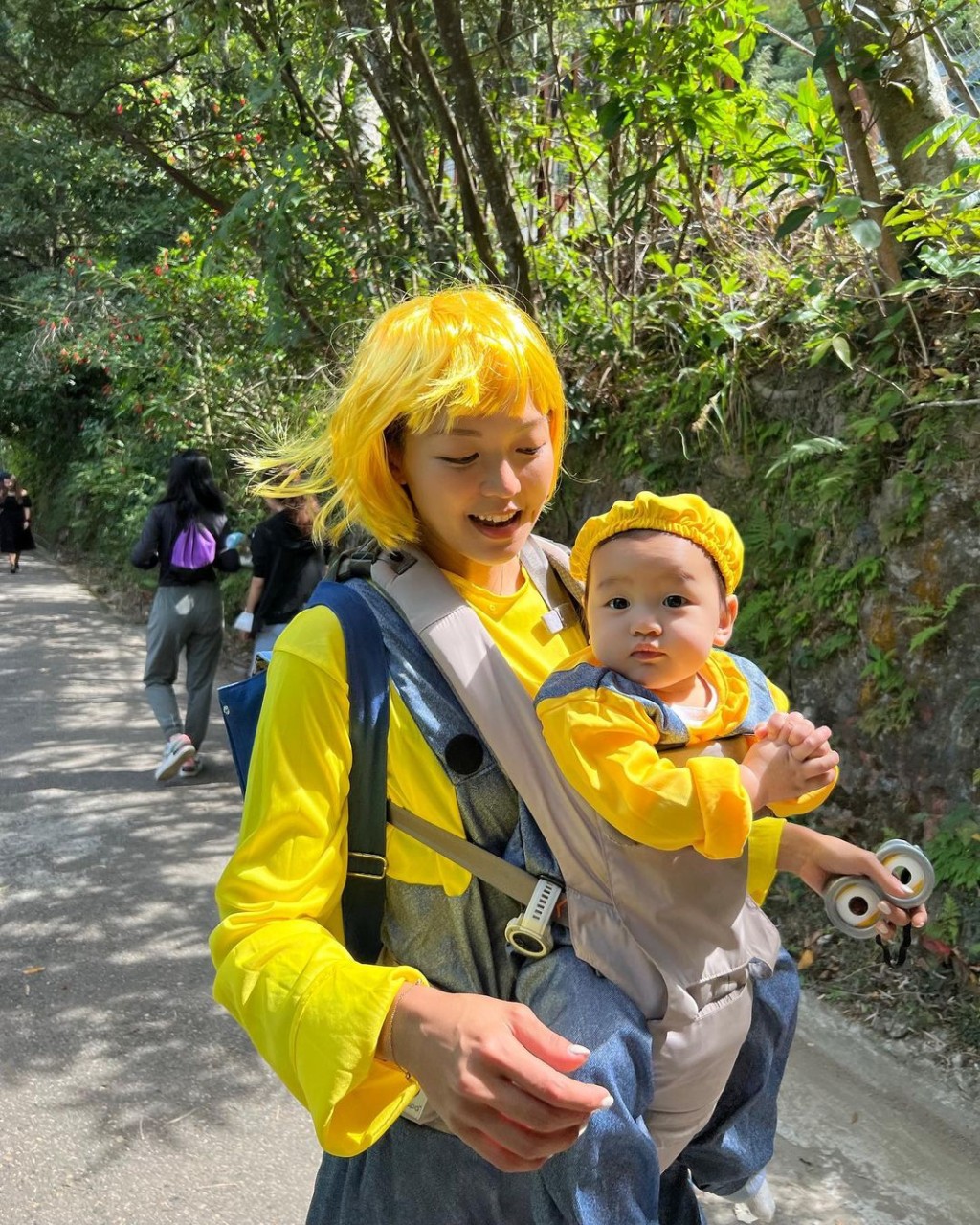 洪永城老婆梁諾妍戴上黃色假髮，抱着囝囝一齊行山過萬聖節。