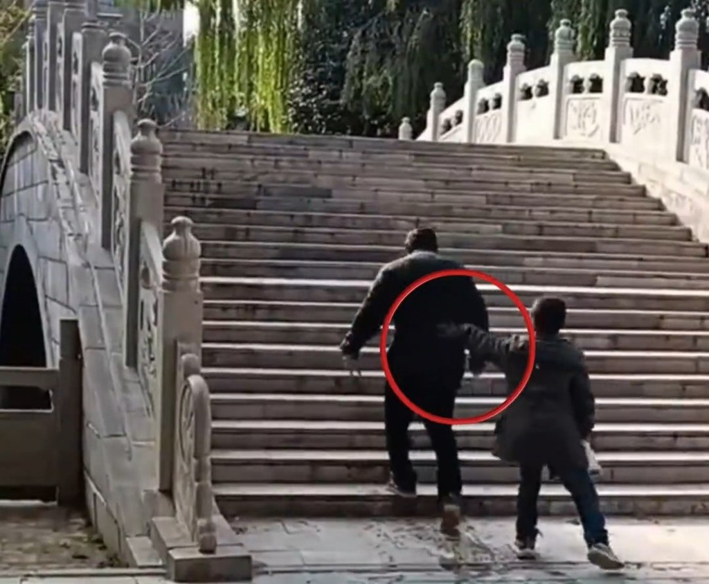 同行男孩不斷推著老翁。
