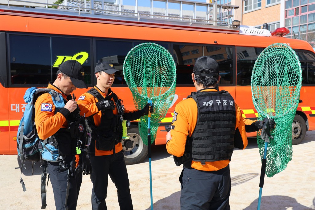 搜索人員攜同捕網搜捕。法新社 搜索人員攜同捕網搜捕。法新社