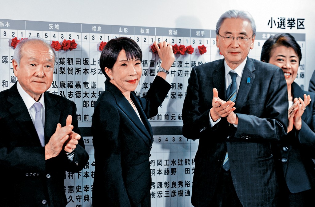 日本首相高市早苗在東京自民黨總部，用圖釘標記贏得眾議院選舉的本黨候選人姓名。 