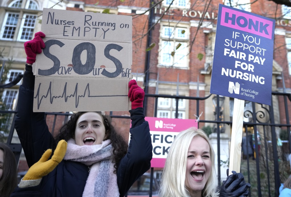 罢工护士站在伦敦皇家马斯登医院外，向来往的车辆举牌示威。AP