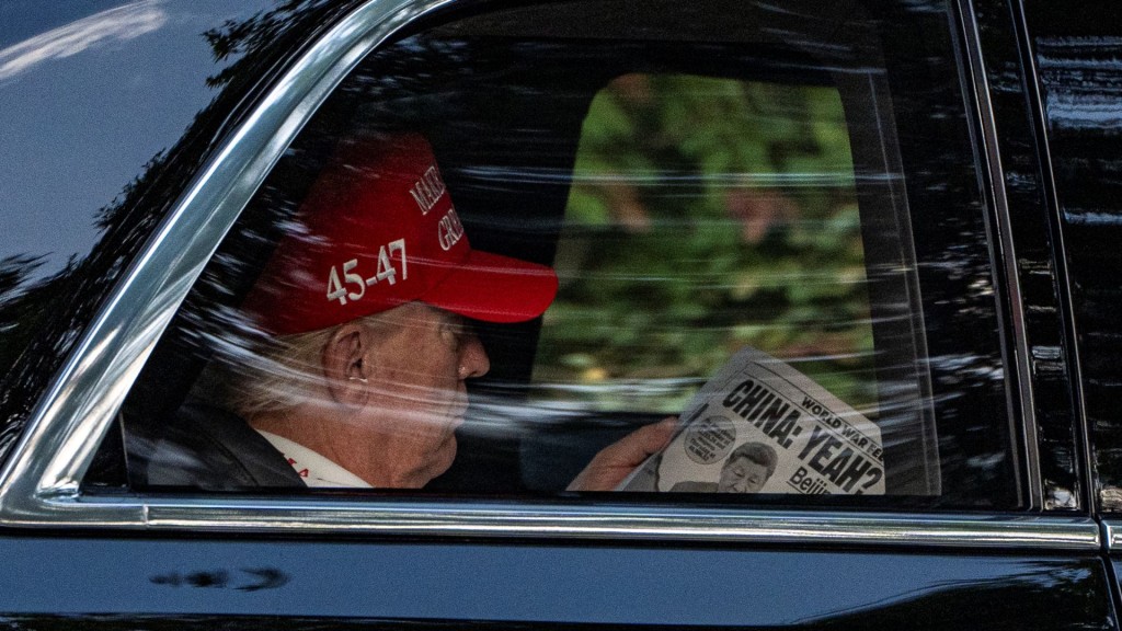 特朗普抵达高球场时，在车上看《纽约邮报》。 美联社