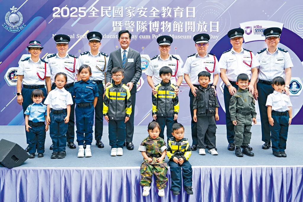 警務處昨舉辦「全民國家安全教育日暨警隊博物館開放日」，財政司副司長黃偉綸(後排左四)、警務處處長周一鳴(後排右四)和警隊高層帶領身穿迷你警察制服的小朋友主持開幕禮。