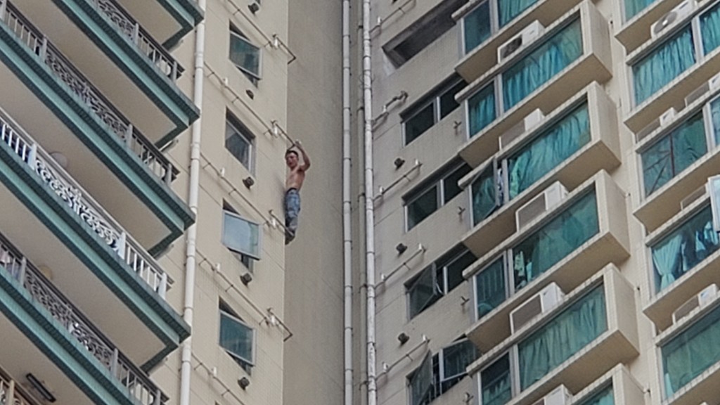 男子在大廈外牆攀爬，險象環生。蔡楚輝攝