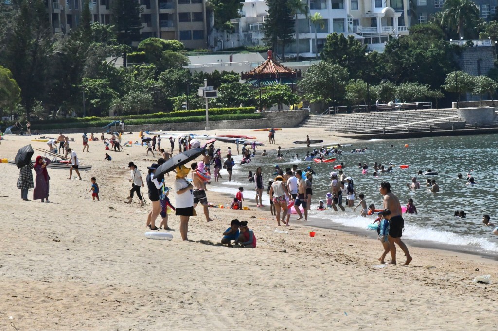 大批市民涌去沙滩玩水消暑降温。
