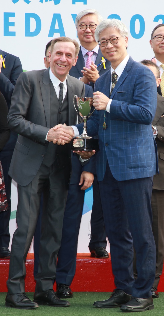 電視廣播有限公司總經理（商務營運）蕭世和先生（右）頒發獎盃予「健康快駒」的練馬師蔡約翰。