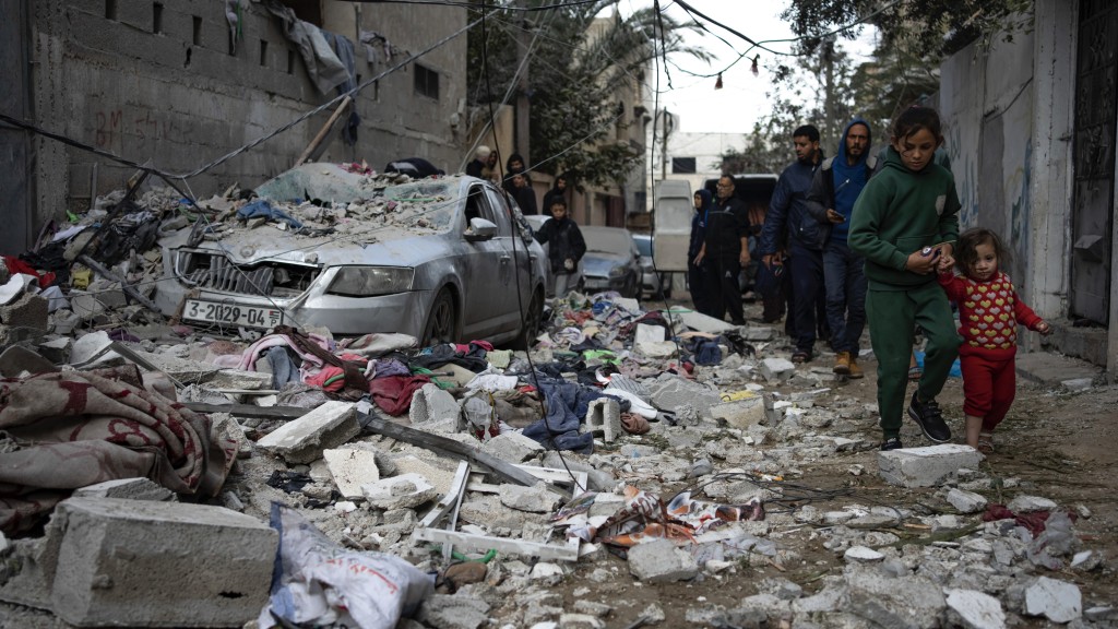 巴勒斯坦人看着以色列空襲加沙拉法所造成的破壞。 美聯社