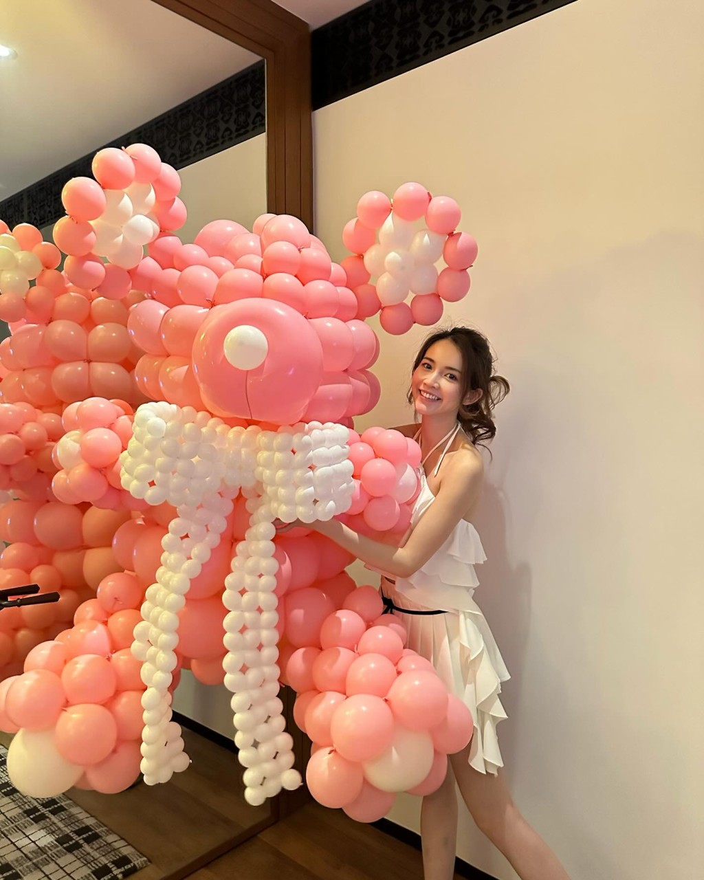 寿星女打扮性感，身穿吊带露背top及短裙的她兴奋地拿起约1米高的粉红气球熊仔。