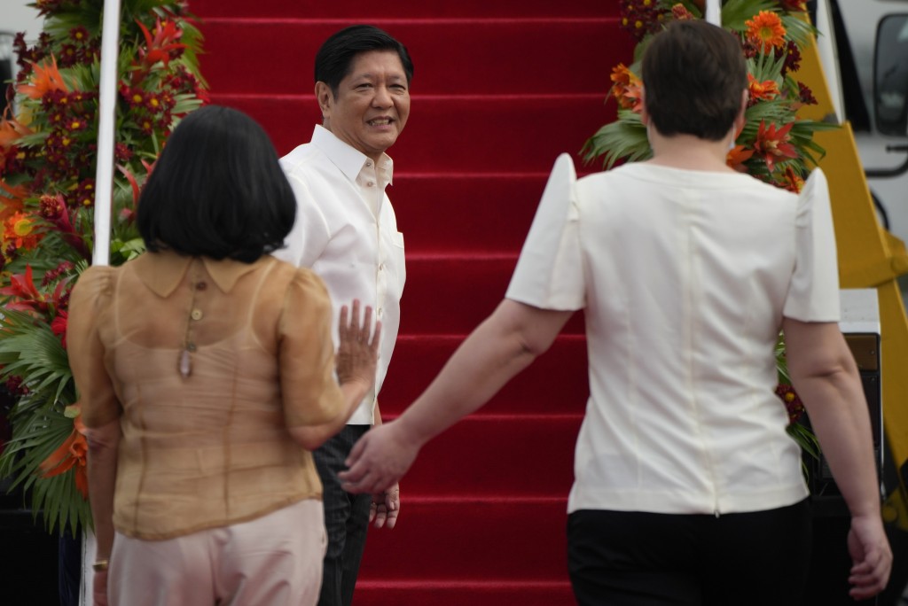 菲律宾总统小马可斯（中）登上飞往中国的飞机前，看著他的妻子玛丽亚·路易斯（左）和副总统萨拉·杜特尔特。AP