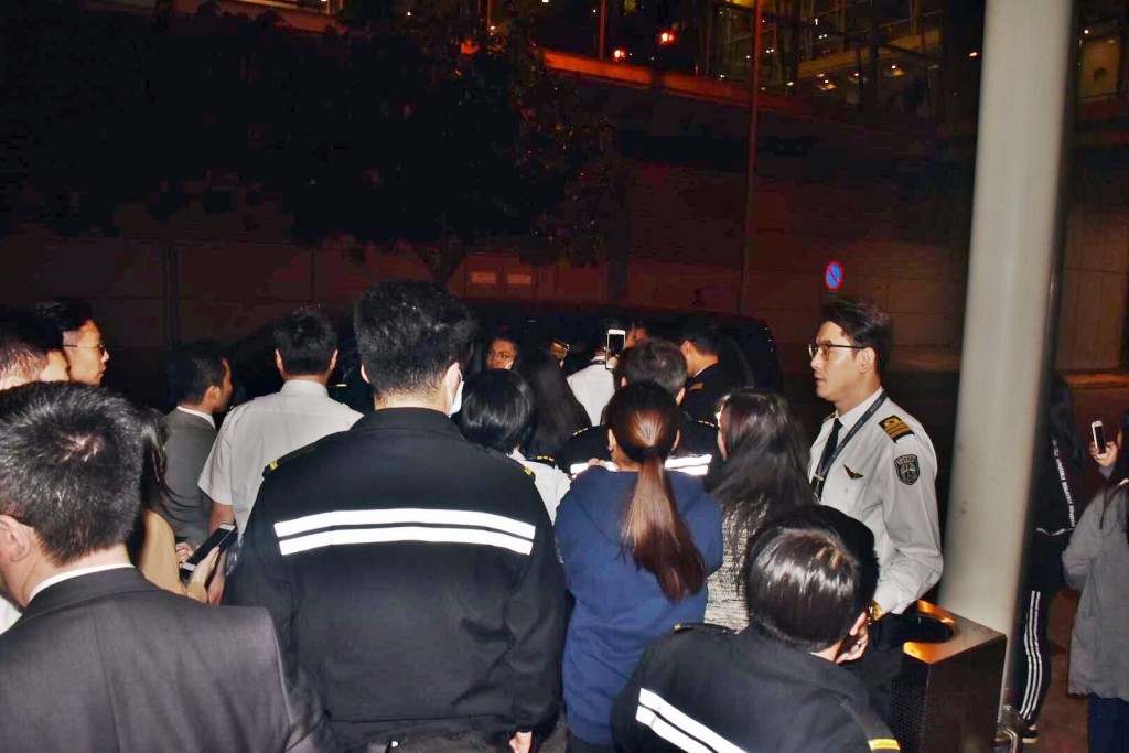 戴着口罩的张艺兴已上车，向车外粉丝挥手。